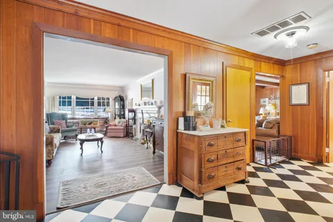 a living room with furniture and a dining table with wooden floor