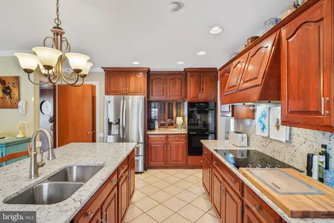 a kitchen with stainless steel appliances granite countertop a sink dishwasher a refrigerator and a stove