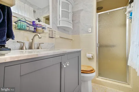 a bathroom with a granite countertop sink toilet and shower