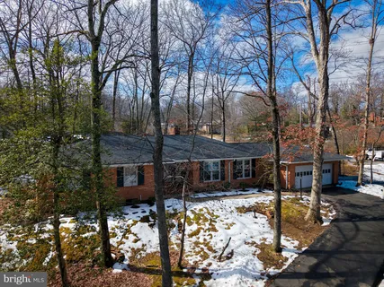 a view of a house with snow on the side of the road