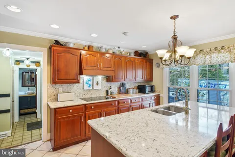 a kitchen with stainless steel appliances granite countertop a sink and a wooden cabinets