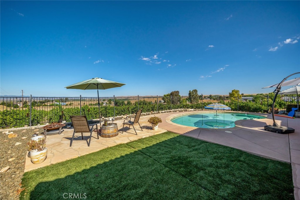 6172 Hawk Ridge Place San Miguel, CA 93451 - Photo 15 of 74 a view of a swimming pool with lawn chairs under an umbrella
