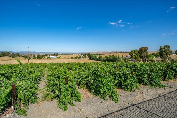 a large kitchen with stainless steel appliances granite countertop a sink and wooden cabinets