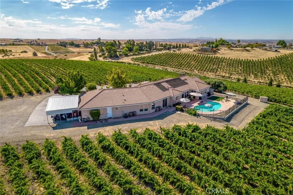 an aerial view of a house with a garden and lake view