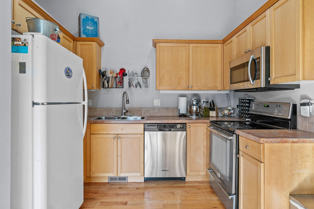 3144 Northeast Wells Acres Road Bend, OR 97701 - Photo 8 of 24 a kitchen with stainless steel appliances granite countertop a refrigerator a stove a sink and a microwave