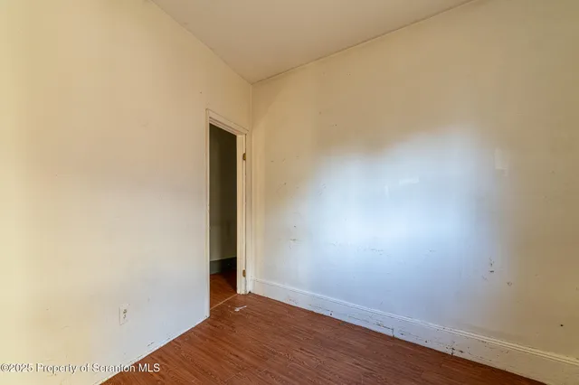 a kitchen with a stove a refrigerator and white cabinets
