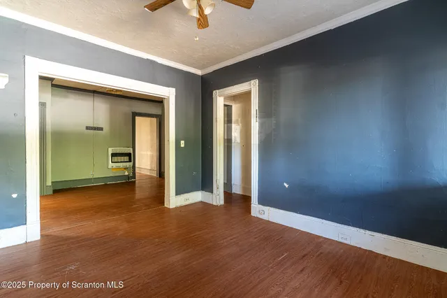 a view of empty room with wooden floor