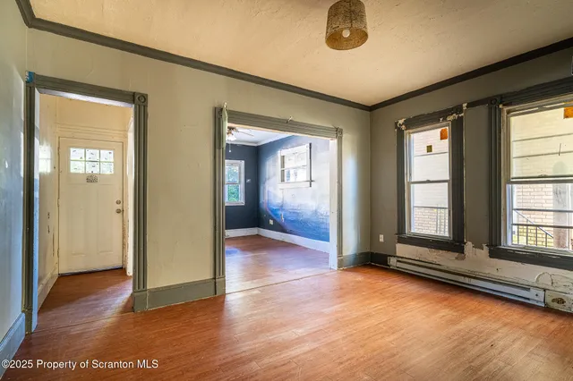 a view of a room with wooden floor and window