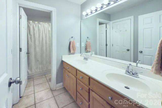 a bathroom with a double vanity sink mirror and shower