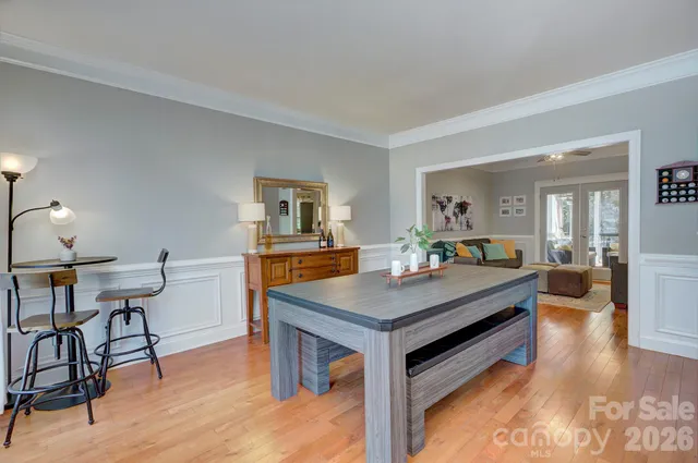 a room with furniture pool table wooden floor and windows