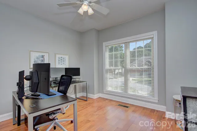 a view of a workspace with furniture and a window