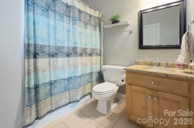a bathroom with a toilet sink vanity and mirror