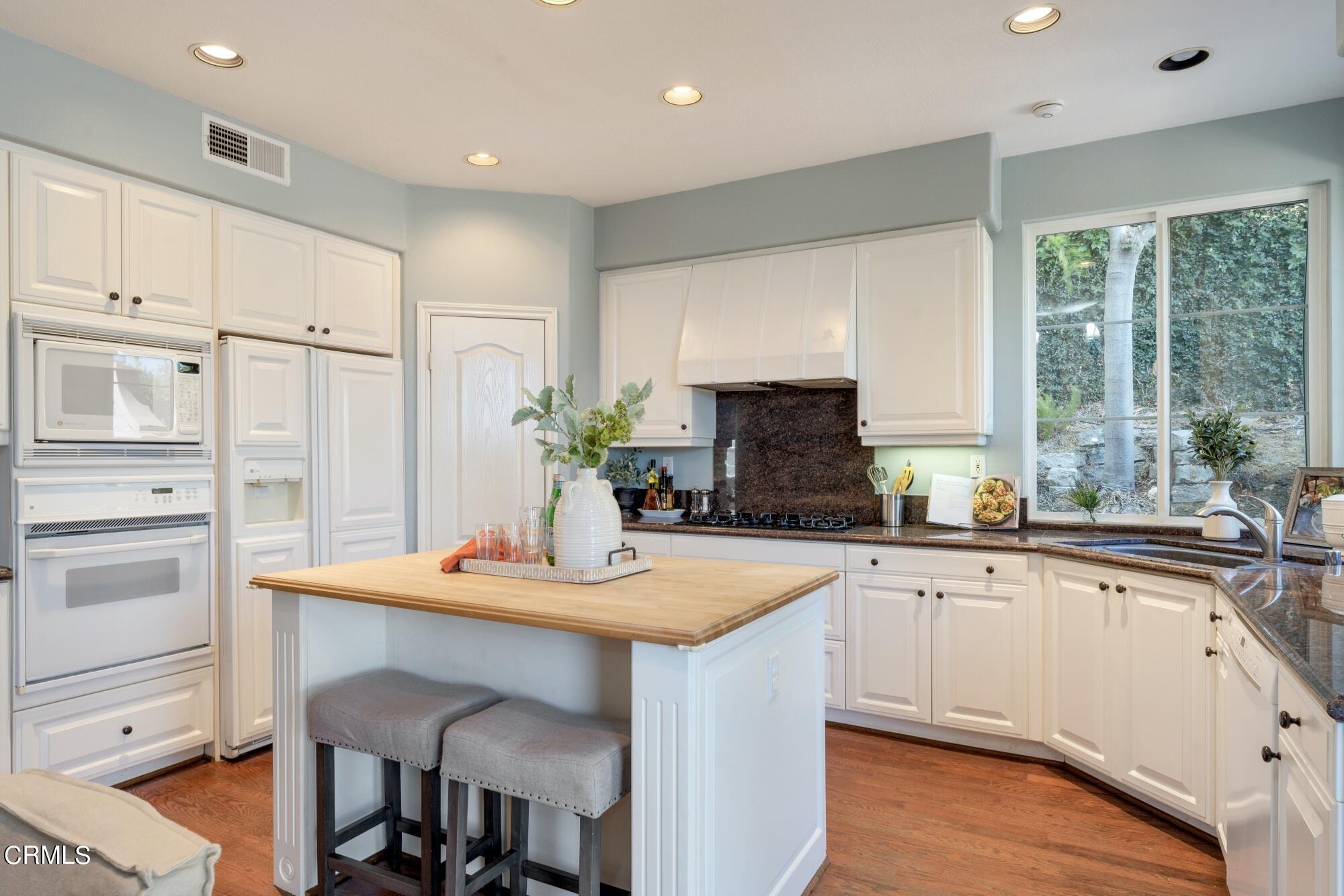 3658 Giddings Ranch Road Altadena, CA 91001 - Photo 19 of 53 a kitchen with white cabinets and wooden floor