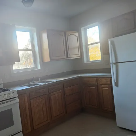 a kitchen with a sink a refrigerator and window