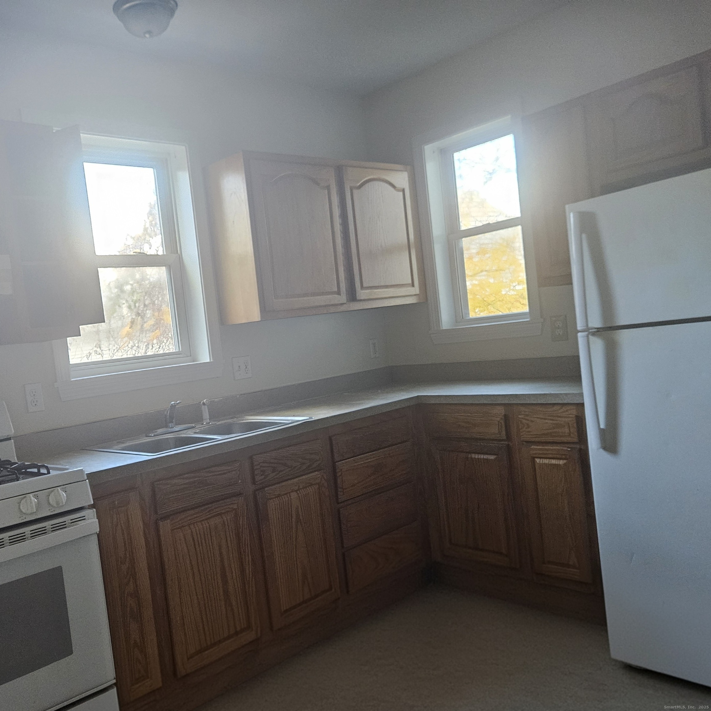 35 Lawrence Street Waterbury, CT 06708 - Photo 3 of 11 a kitchen with a sink a refrigerator and window