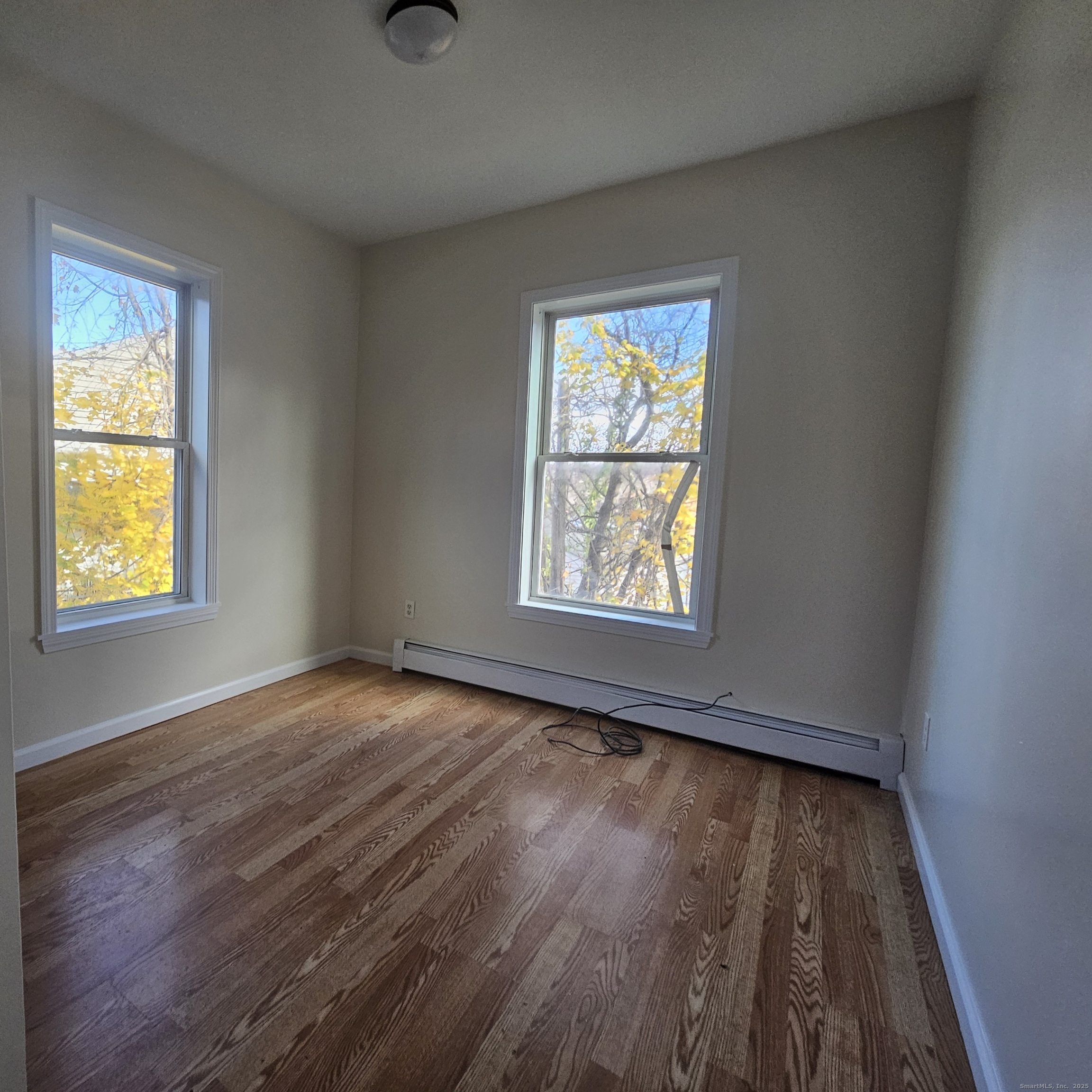 35 Lawrence Street Waterbury, CT 06708 - Photo 10 of 11 an empty room with wooden floor and windows