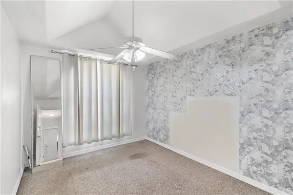 en empty room with windows and chandelier fan