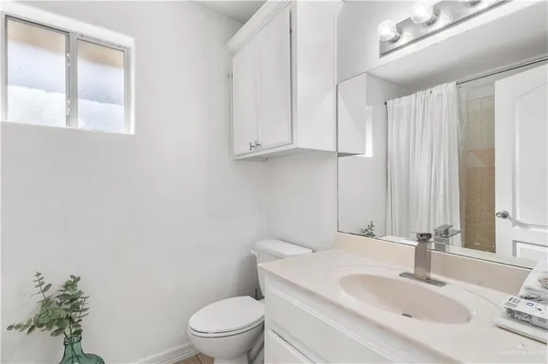 a bathroom with a sink a toilet and a mirror