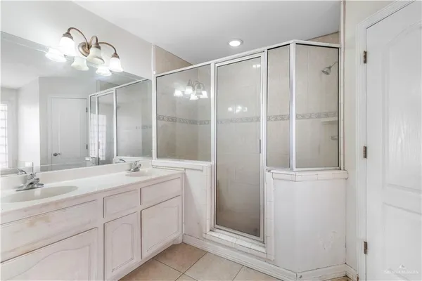 a bathroom with a double vanity sink mirror and shower