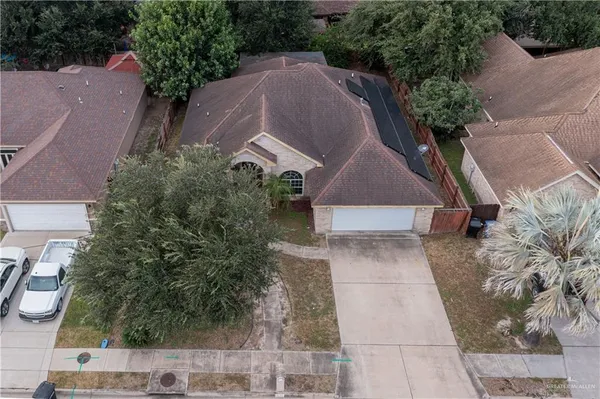 an aerial view of a house with a yard and greenery