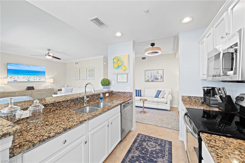 9715 Acqua Court, Unit 116 Naples, FL 34113 - Photo 8 of 43 a kitchen with granite countertop a sink stove and cabinets