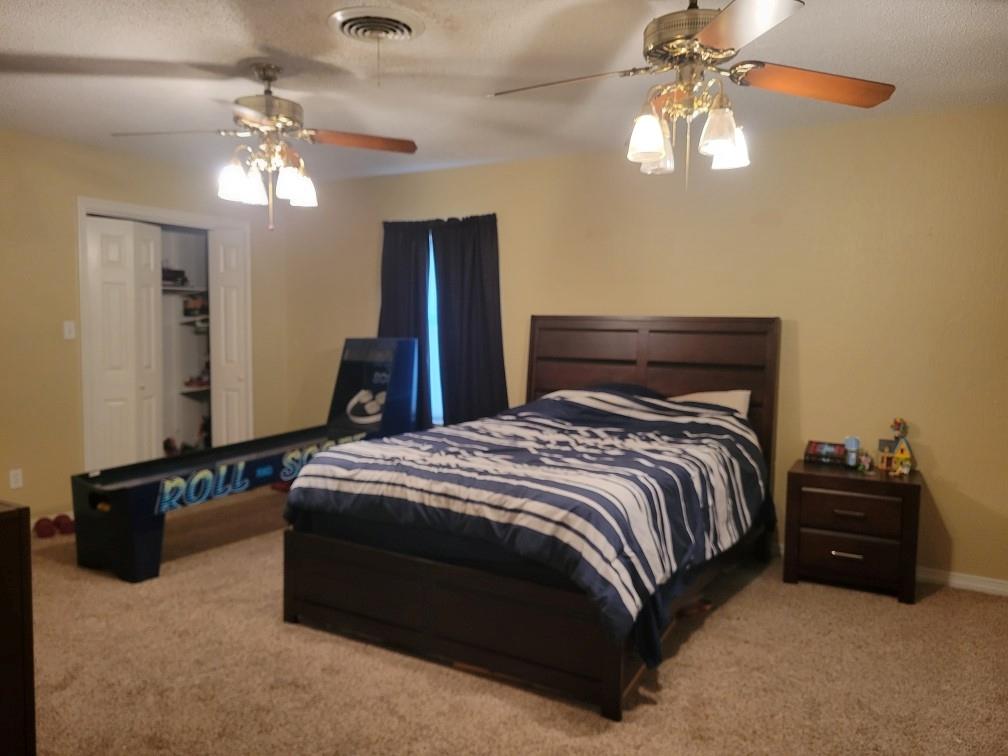 1440 South Keller Road Mineral Wells, TX 76067 - Photo 19 of 24 a bedroom with a bed and a chandelier