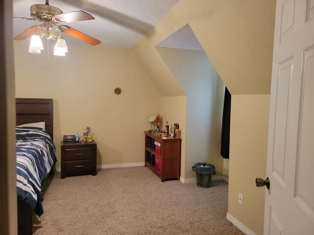 1440 South Keller Road Mineral Wells, TX 76067 - Photo 21 of 24 a bedroom with a bed and a chandelier