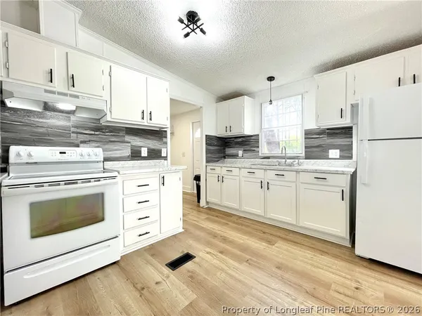 a kitchen with cabinets stainless steel appliances and sink