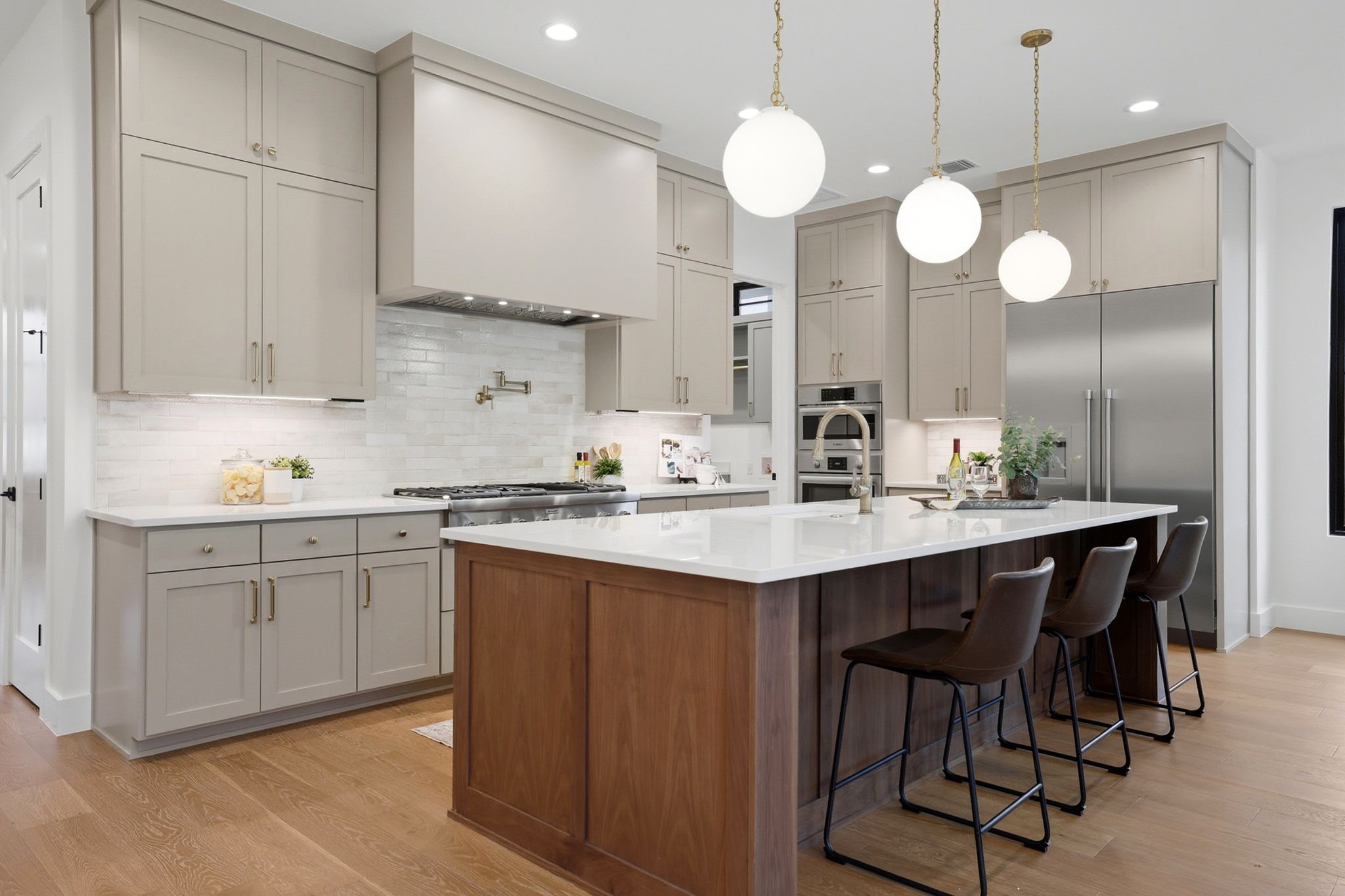 6611 Lexington Road Austin, TX 78757 - Photo 10 of 37 Gourmet kitchen featuring a wood-finish island with a white countertop, light-colored cabinetry, stainless steel appliances, and wood-finish flooring