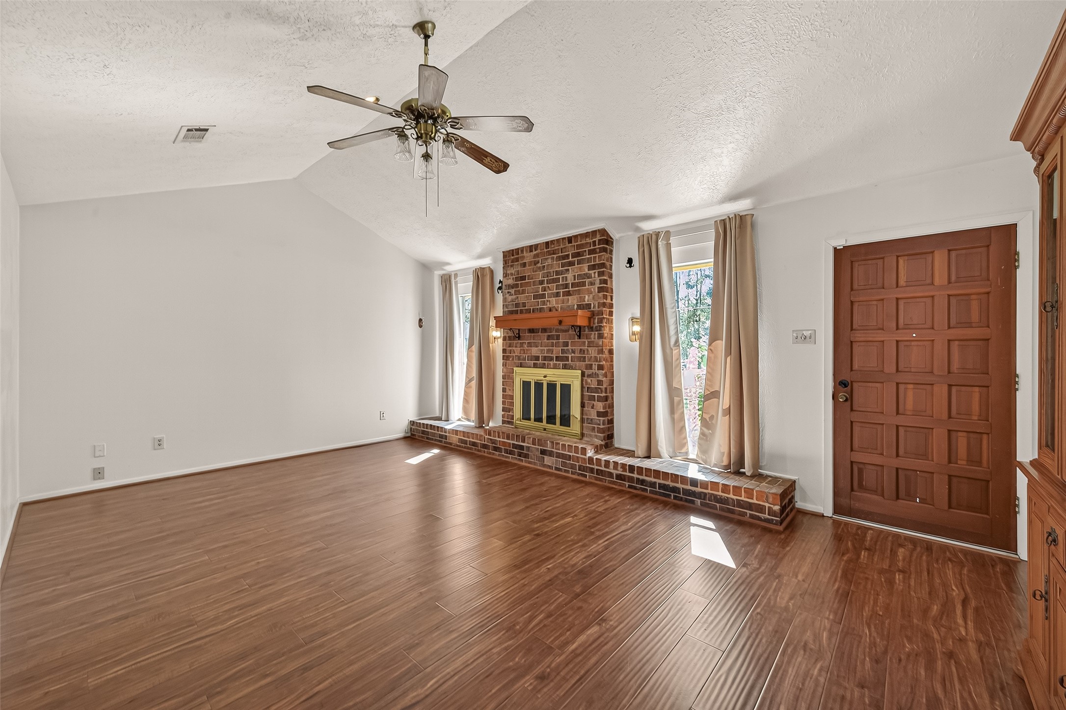 11535 Willis Waukegan Road Conroe, TX 77303 - Photo 11 of 47 an empty room with wooden floor fan and windows