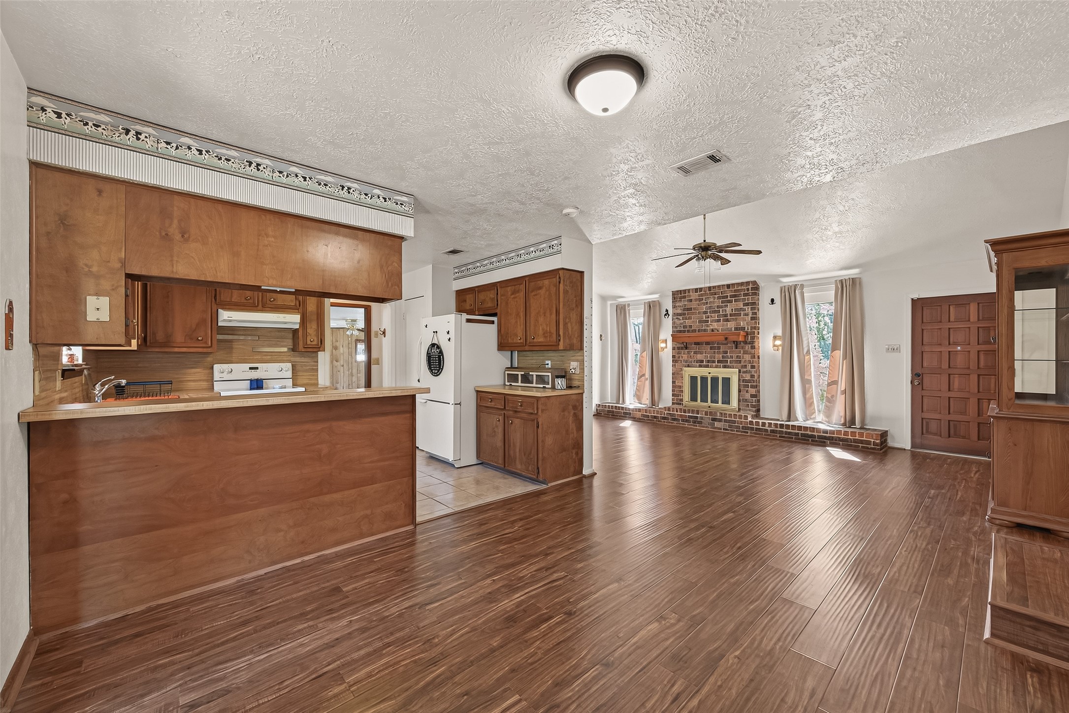 11535 Willis Waukegan Road Conroe, TX 77303 - Photo 17 of 47 a large kitchen with cabinets wooden floor and a refrigerator