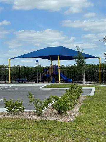 a view of a garden with lawn chairs under an umbrella