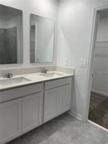 a spacious bathroom with 2 sink and a mirror
