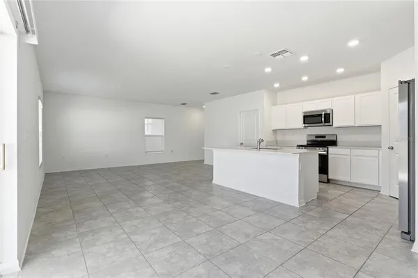 a kitchen with kitchen island a sink stove and refrigerator