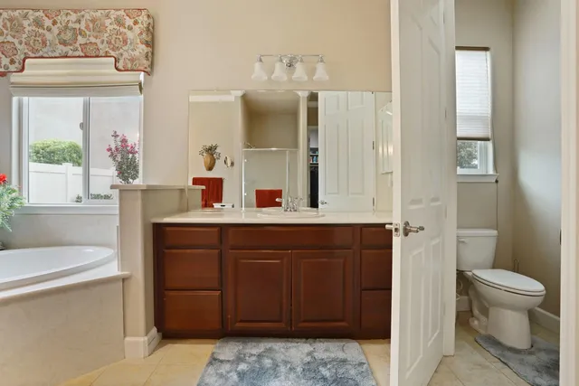 a view of an empty room with kitchen and window