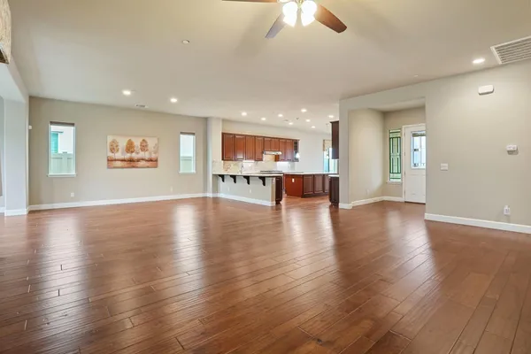 a living room with stainless steel appliances kitchen island granite countertop wooden cabinets and entryway