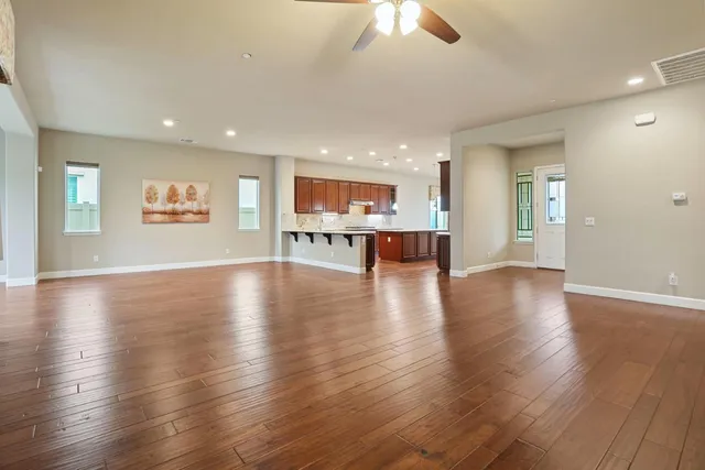 a living room with stainless steel appliances kitchen island granite countertop wooden cabinets and entryway