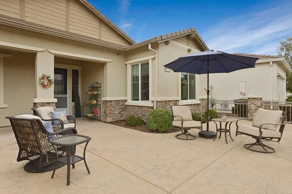 a front view of a house with a yard and potted plants