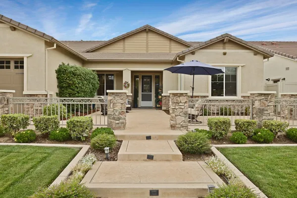 a view of a patio with couches table and chairs under an umbrella