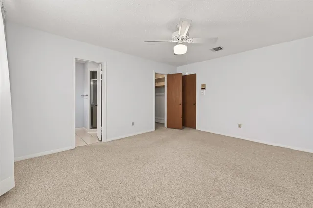 a view of an empty room with a chandelier fan
