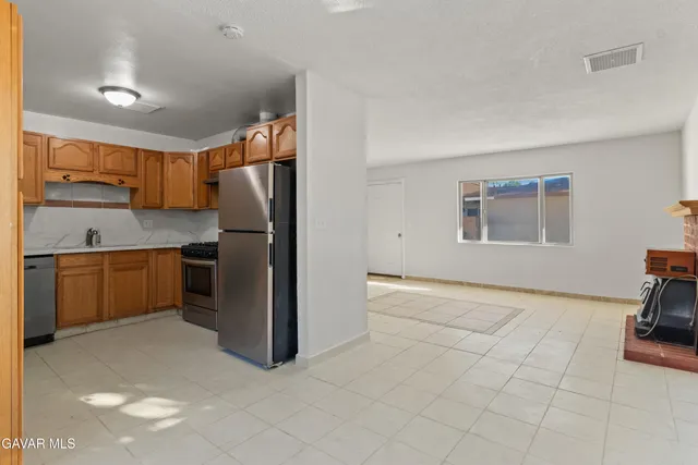 a kitchen with stainless steel appliances granite countertop a refrigerator and a stove