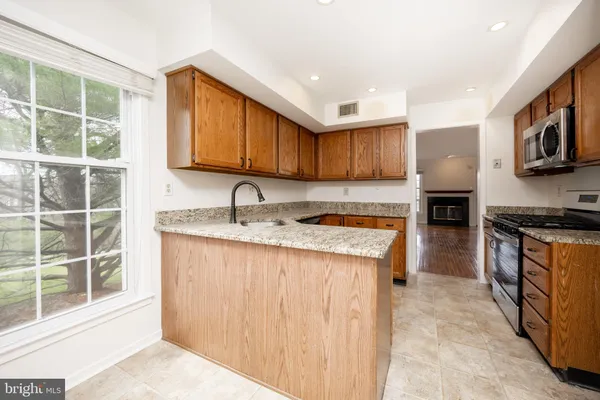 a kitchen with stainless steel appliances granite countertop a stove a sink and a microwave