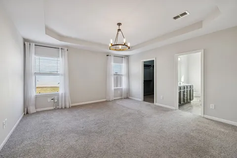 a view of a room with a hanging light and kitchen