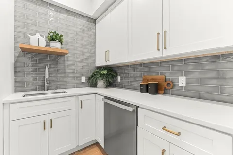 a spacious bedroom with a bed a couch and a large window