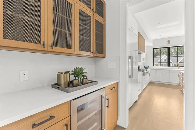 a kitchen with stainless steel appliances a stove and white cabinets next to a window