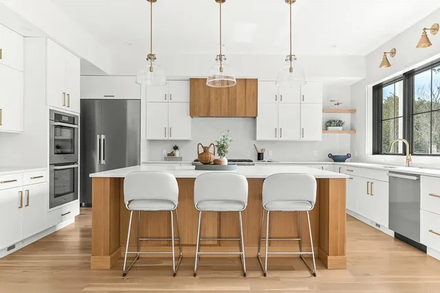 a kitchen with stainless steel appliances kitchen island granite top and refrigerator