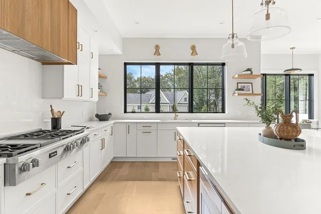 a kitchen with stainless steel appliances granite countertop a sink a stove and a wooden floors