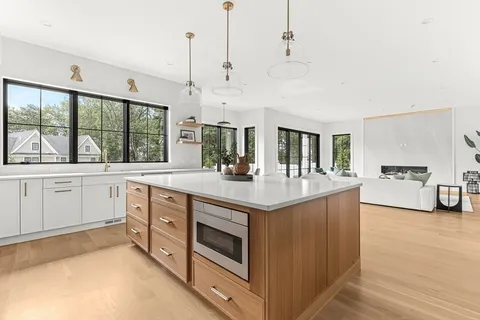 a kitchen with stainless steel appliances kitchen island granite countertop a table chairs sink and cabinets