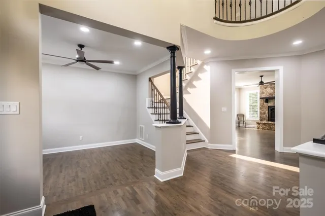 an empty room with windows fireplace and wooden floor