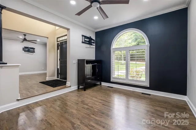 an empty room with windows fireplace and wooden floor